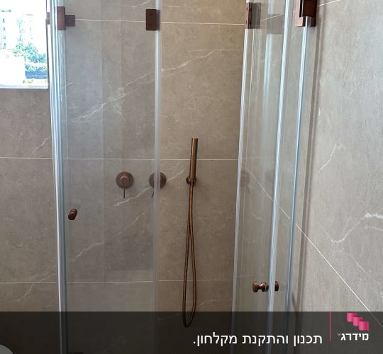 מקלחון זכוכית עם ראש מקלחת על קיר